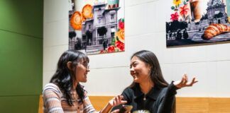 Dos personas conversan frente a frente en una cafetería, ilustración de diálogo y escucha