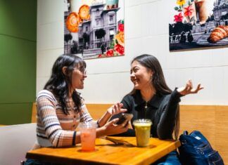 Cómo saber si una persona miente: señales que no son fiables Dos personas conversan frente a frente en una cafetería, ilustración de diálogo y escucha