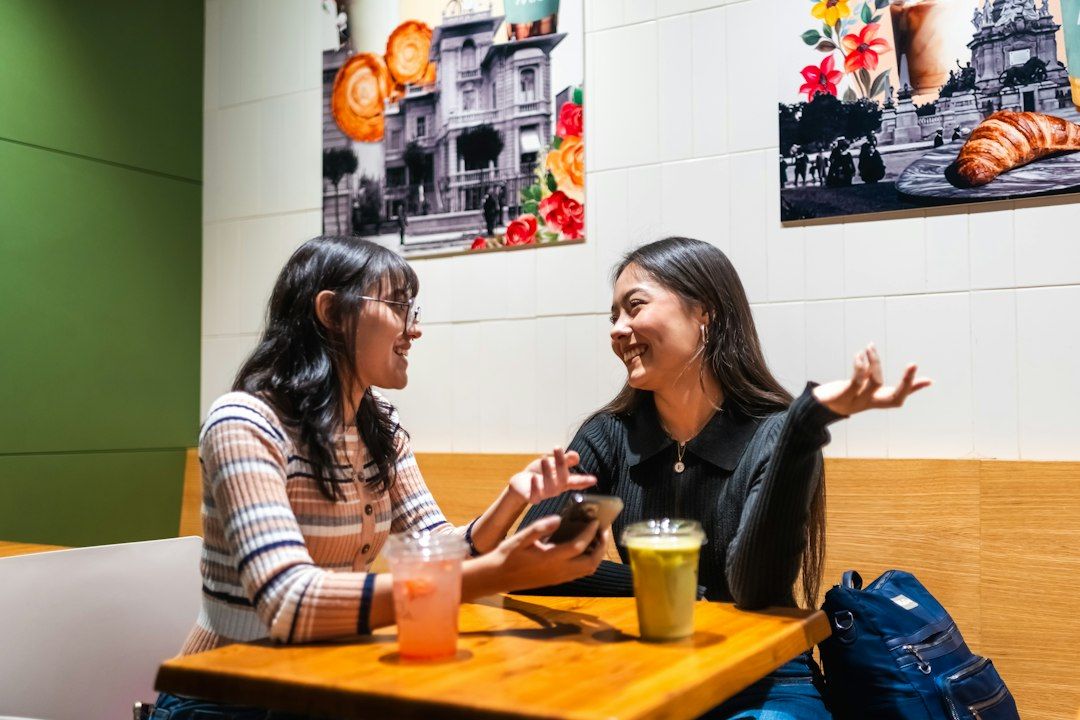 Dos personas conversan frente a frente en una cafetería