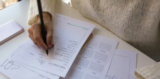 Persona escribiendo sobre una hoja de papel con un bolígrafo, representación de una prueba de evaluación
