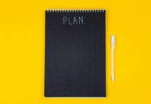 Cómo tomar buenas decisiones: factores, sesgos y un método práctico Cuaderno con la palabra plan y marcador sobre una mesa amarilla