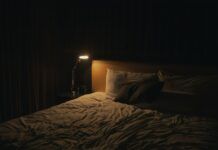Suplementos para dormir: melatonina, magnesio y valeriana a examen Lámpara de noche encendida junto a la cama, imagen ilustrativa de hábitos de sueño